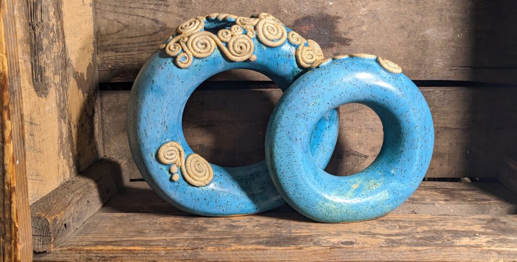 Double donut vase - two toroid forms in PSH 455 speckle clay with matte turquoise glaze and unglazed embellishments.